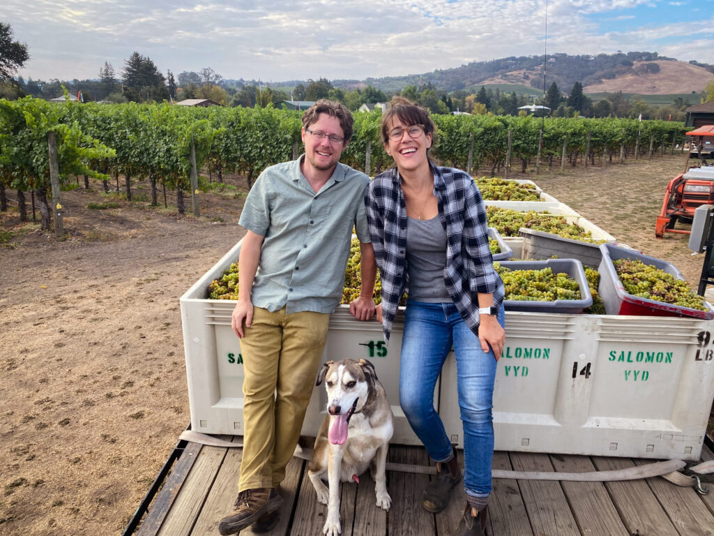 Rob, Laura, and their dog Eli Schermeister with Viognier grapes in the vineyard